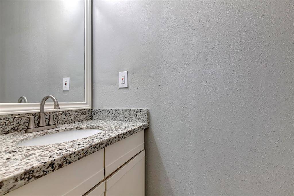 The half bath is conveniently located at the center of the dining area, living room, and kitchen, providing easy access from all main living spaces.