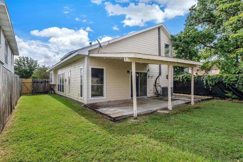 Another view of the back of the house showcases the backyard, which is covered in lush green grass—ideal for outdoor activities or relaxing in the open space.