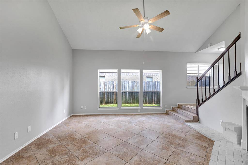 A wider view of the living room highlights the expansive windows that bring in plenty of natural light, creating a bright and welcoming atmosphere.