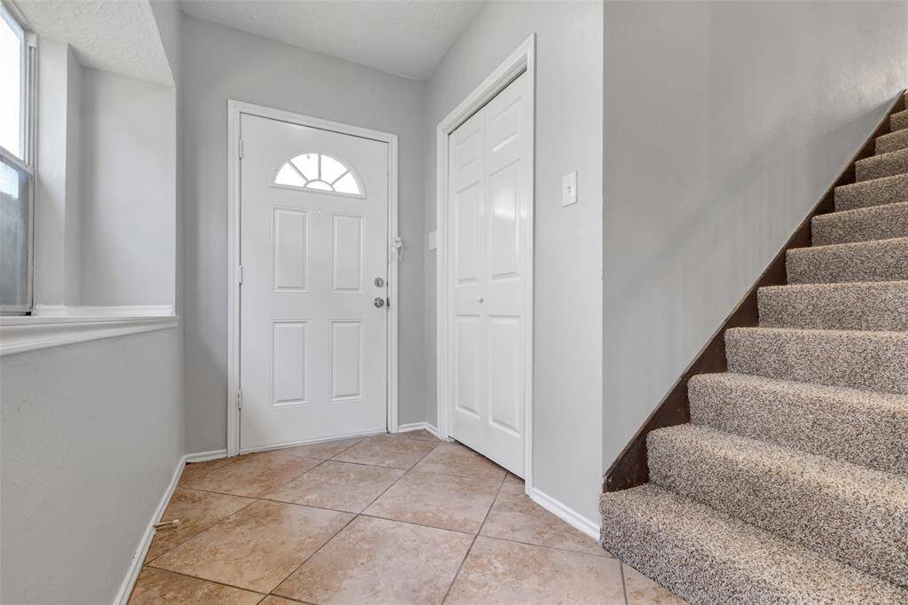 A closer look at the foyer reveals a side door that leads to a convenient coat closet, adding practical storage near the entrance.