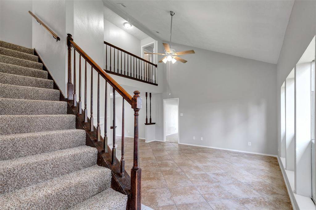 Just off the entrance, a carpeted staircase leads to the second floor, adding function and comfort to the home's layout.