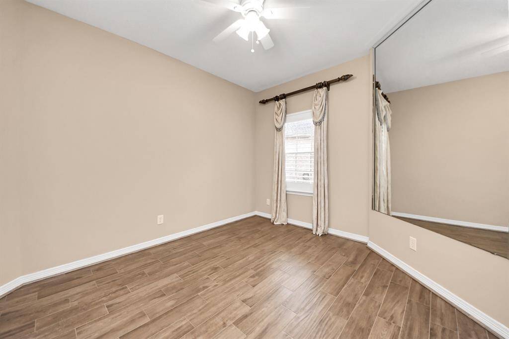 On the other side of the house, just behind the kitchen area, you’ll find the two secondary bedrooms and a full bath. This is one of them—both rooms feature plantation shutters.