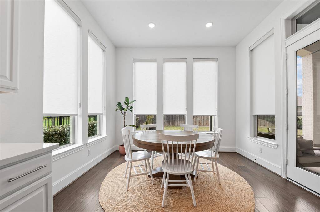 Bright and inviting eating nook surrounded by large windows, filling the space with abundant natural light and offering scenic views