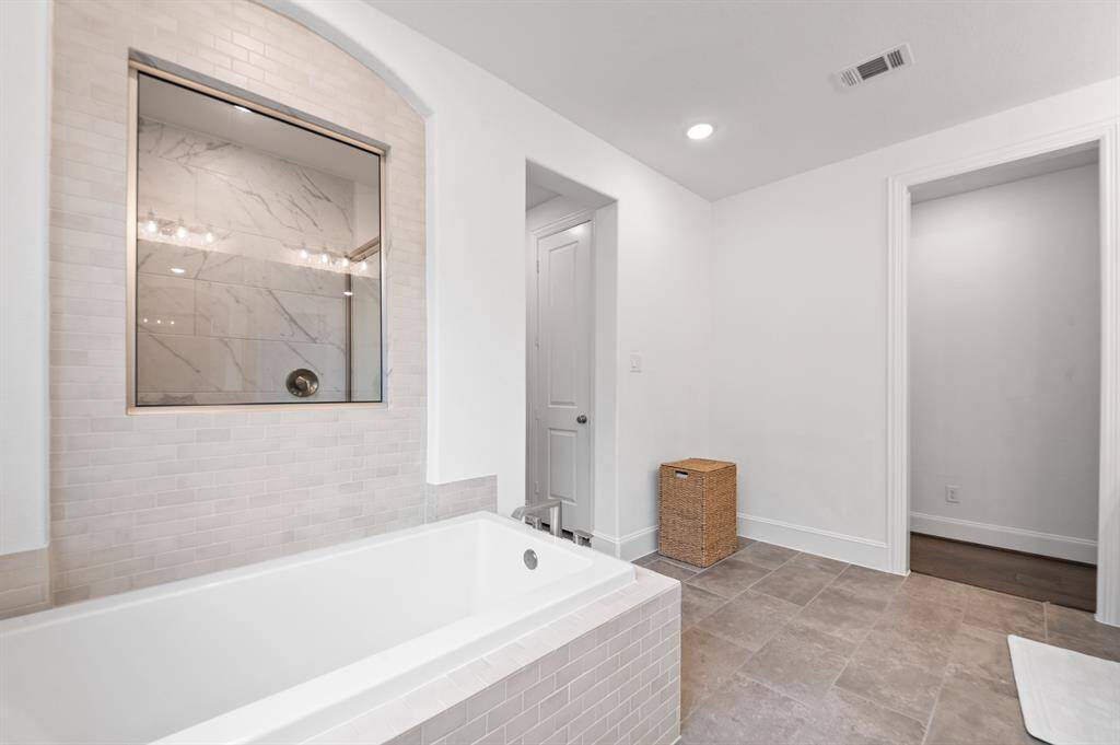 Separate tub and shower in the primary bath, offering the perfect blend of relaxation and functionality with stylish, modern finishes.