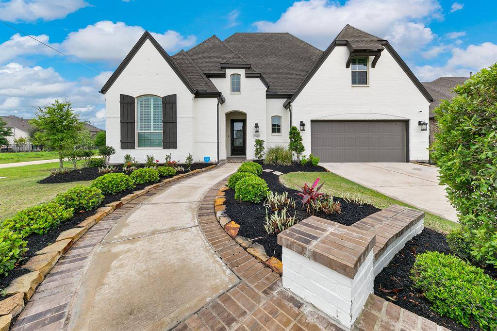 Elegant white brick home nestled on a peaceful cul-de-sac. The inviting exterior showcases timeless architecture with crisp white brick, complemented by manicured landscaping and a welcoming entryway