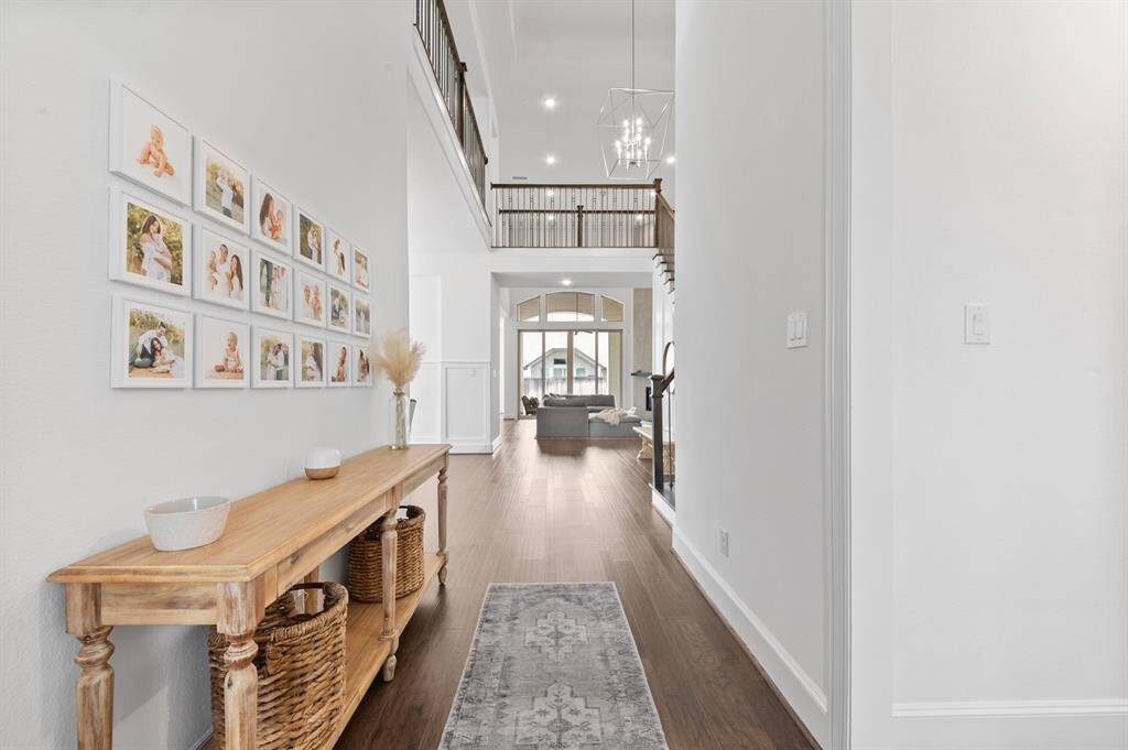 Grand entry with soaring ceilings, elegant lighting, and a beautifully crafted front door, setting the tone for this sophisticated home.