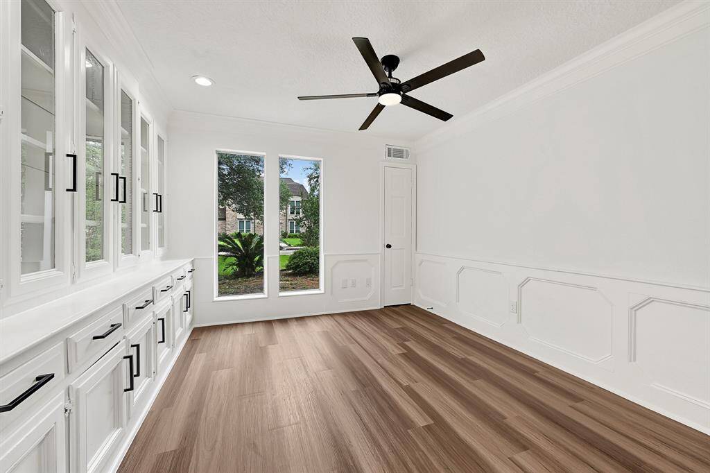 Bright flex space with custom built-ins and oversized windows, perfect for an office, wine room, or private retreat.