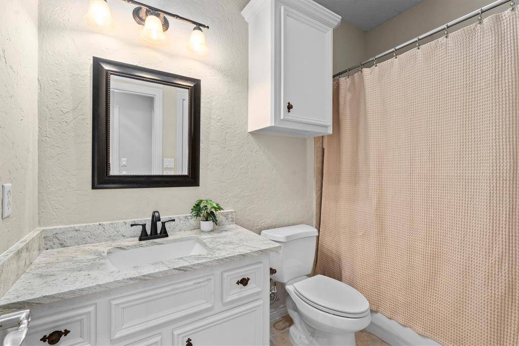 En-suite to bedroom #2 with updated stone counters