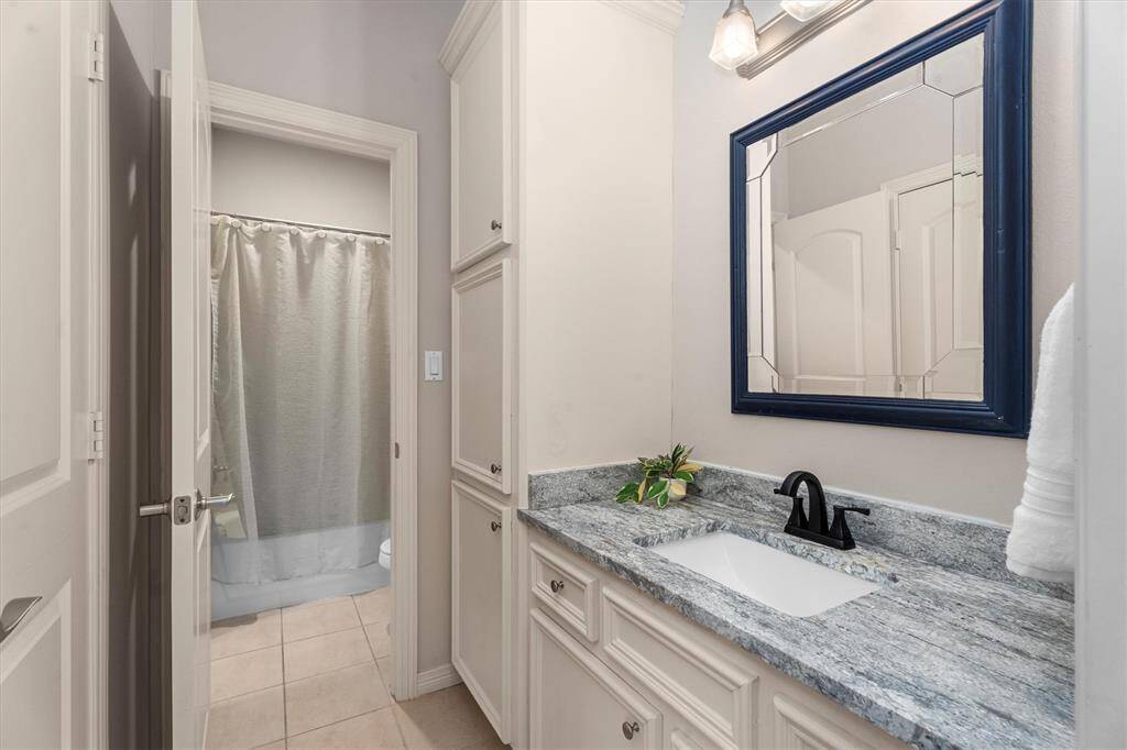 Private vanity area with updated stone counters and part of the Jack and Jill bathroom