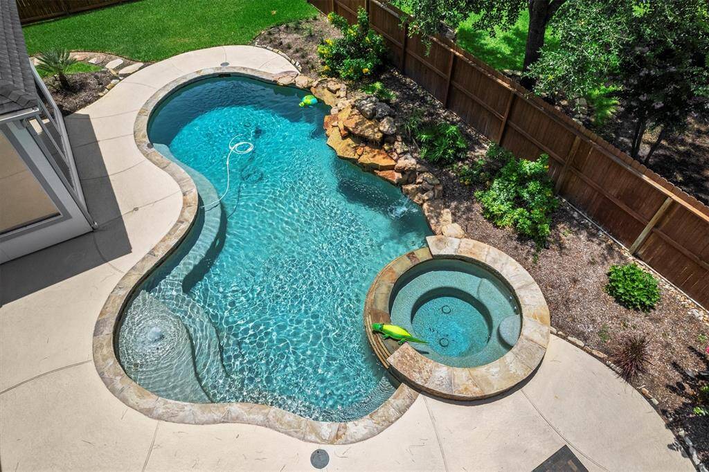 Rock waterfall and expansive decking with outdoor kitchen
