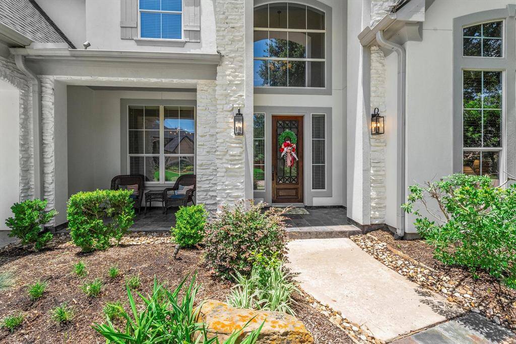 Front porch with natural stone flooring and updated exterior light fixtures