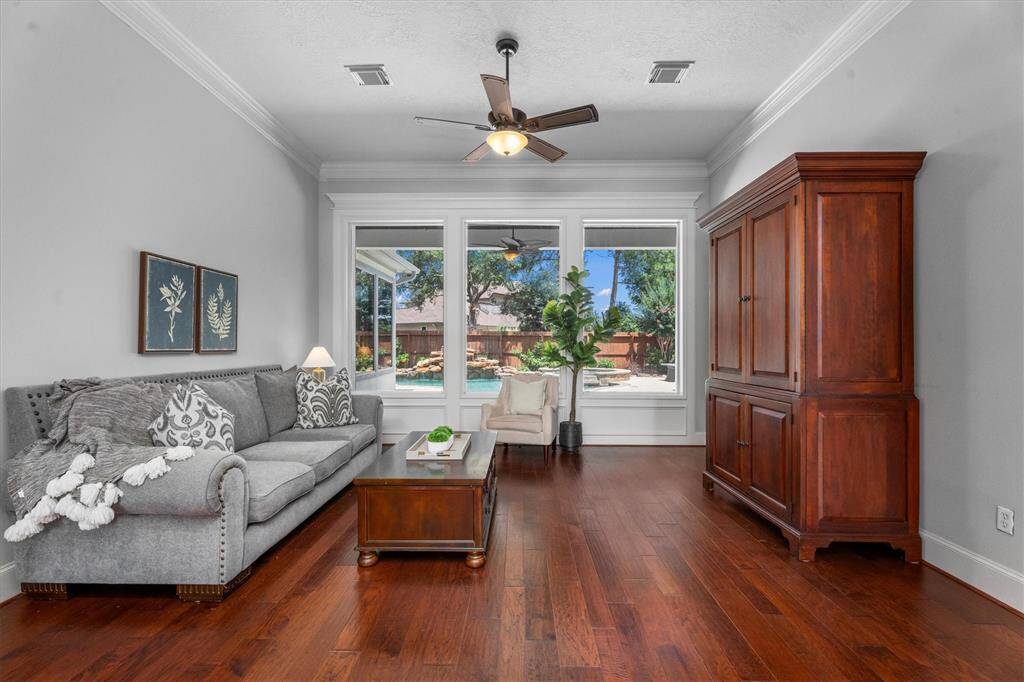 Formal living with large picture windows overlook the serine backyard