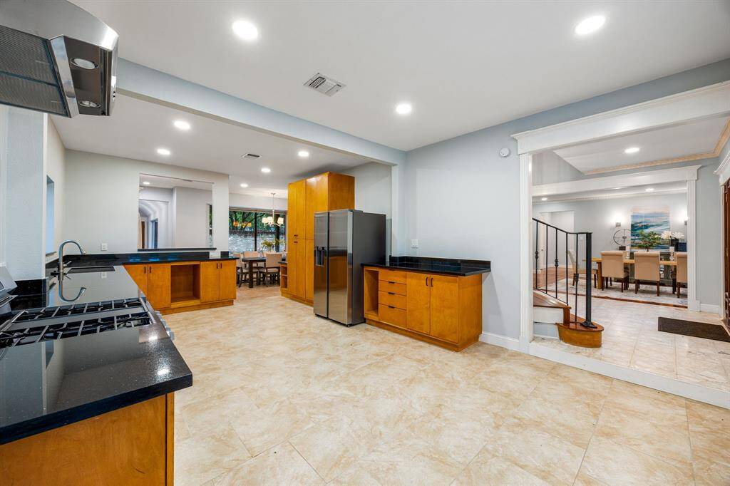 The open-concept kitchen seamlessly connects to the adjacent breakfast area, creating a spacious and inviting atmosphere for gatherings and everyday meals.