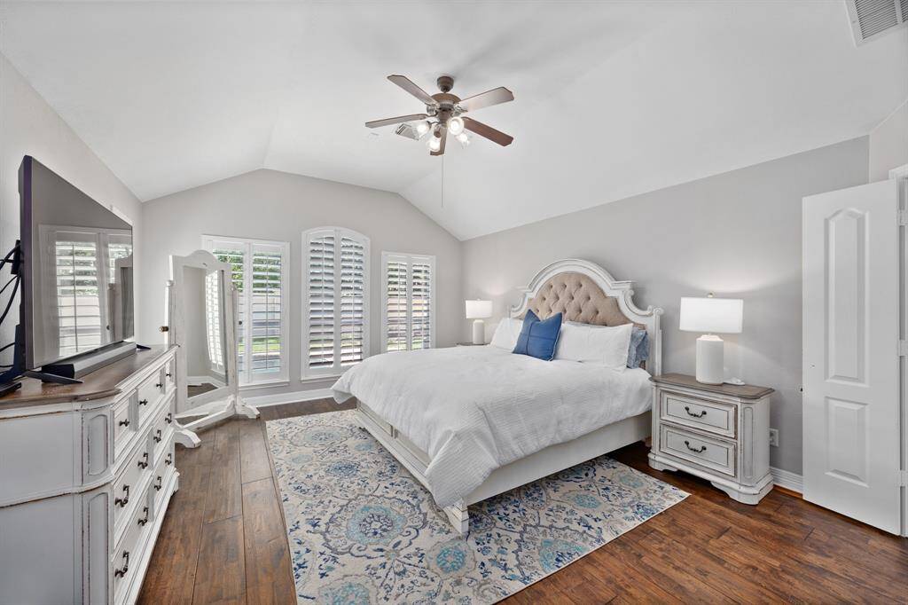 Oversized primary suite is tucked in the back of the home with neutral paint, plantation shutters, and access to the backyard.