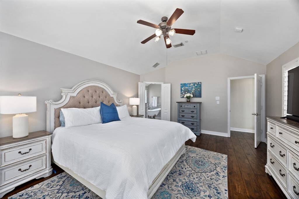 Oversized primary suite is tucked in the back of the home with neutral paint, plantation shutters, and access to the backyard.