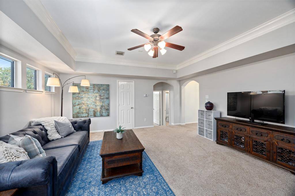 Massive gameroom with tray ceilings and crown molding offers beautiful transom windows filled with natural light.