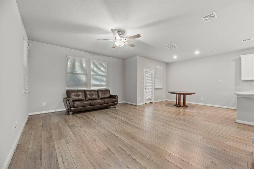 Abundant natural light pours in, beautifully accentuating the richness and warmth of the flooring.