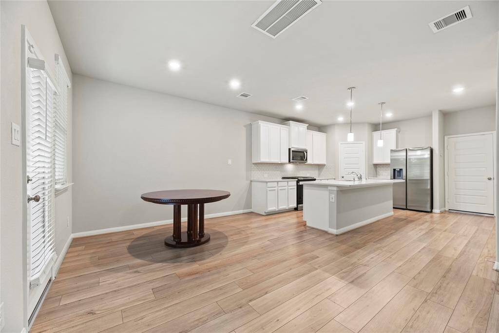 The dining and kitchen areas blend harmoniously, creating a cohesive space ideal for both everyday meals and entertaining.