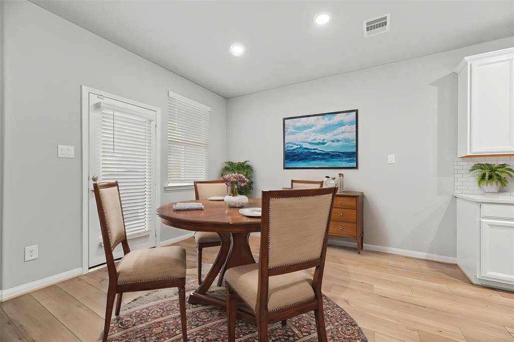 The dining area features a glass door that opens to the back patio, seamlessly blending indoor and outdoor living. - virtually staged