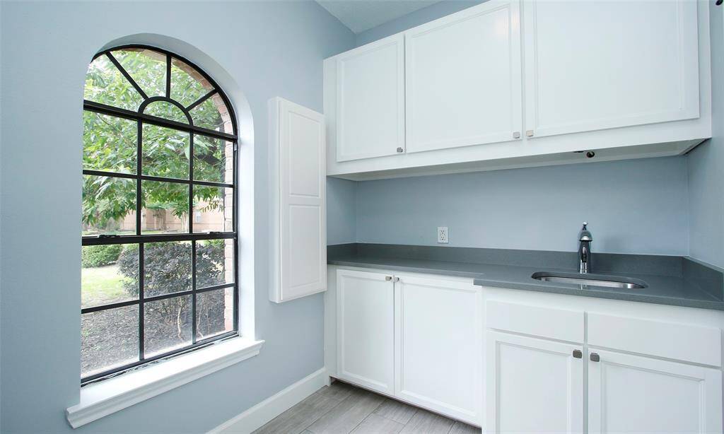 The kitchen features minimalist cabinetry, offering a sleek and modern look with clean lines and a clutter-free design.