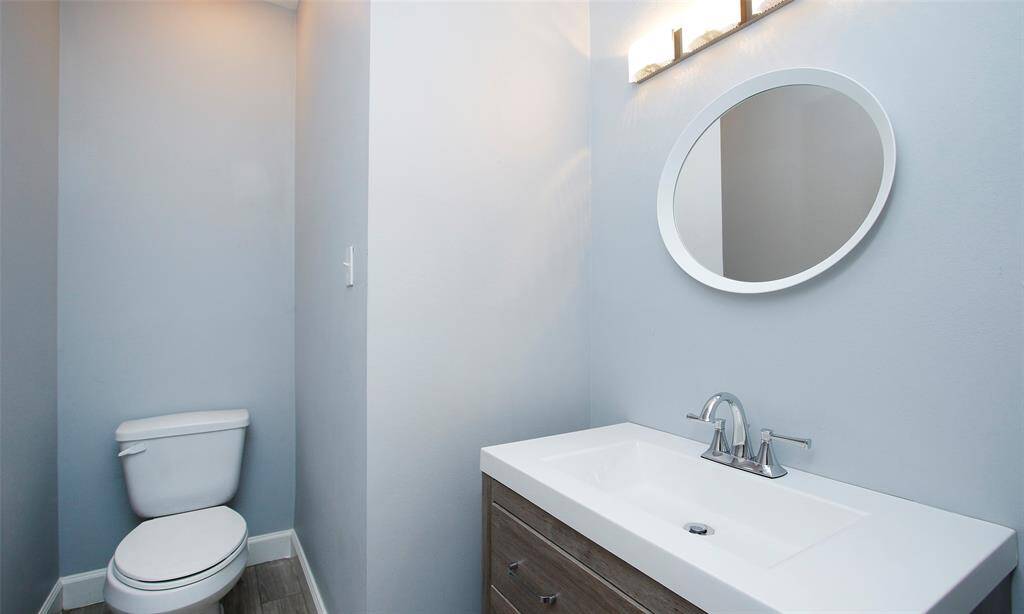 The half bathroom features serene powder blue walls, creating a calm and refreshing atmosphere.