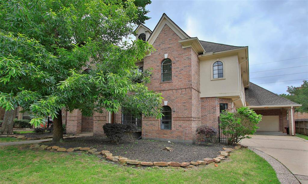 An additional view of the front of the home, showcasing its brick walls. A driveway leads to the detached garage for convenient parking and storage.