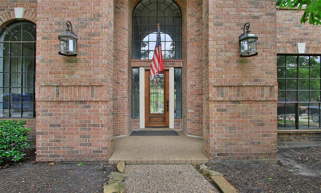 The inviting entrance features charming brick walls, adding character and warmth to the home's exterior.
