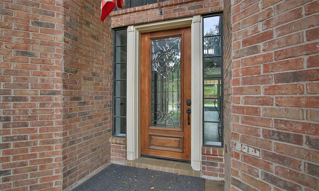 The main door showcases a stylish wooden frame with a glass center, blending elegance and natural light.