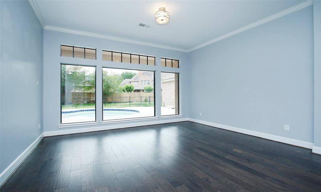 A cozy sitting area with expansive glass windows, offering a beautiful view of the lush backyard.