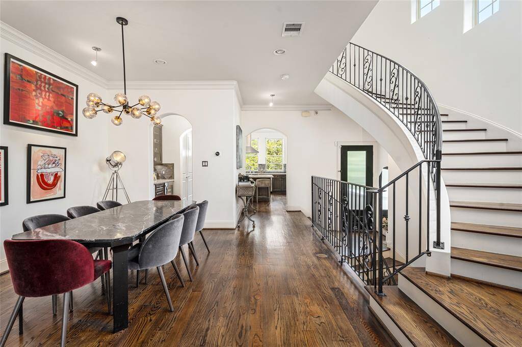 View of the front door, up the staircase into the kitchen from the living room