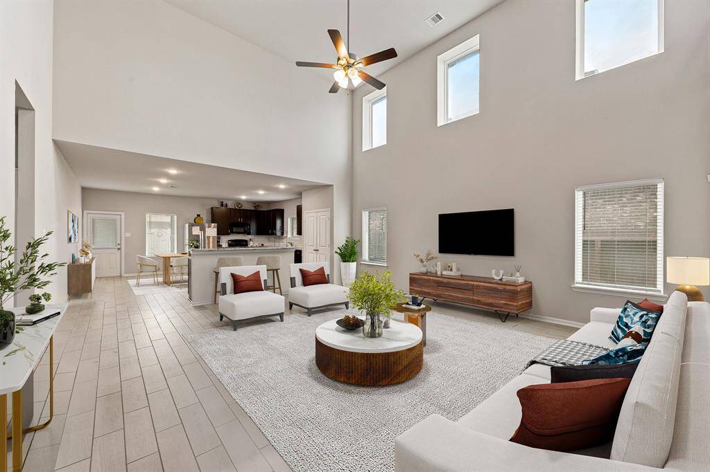 This light and bright spacious living room is the perfect layout for entertaining or just relaxing. Whether it's simply a night in or entertaining family and friends, this home has ample open space for everyone to enjoy! Featuring dark stained ceiling fan, wood style flooring, large windows with blinds, soaring high ceilings, recessed lighting with wonderful access to your gorgeous kitchen. *Virtually Staged