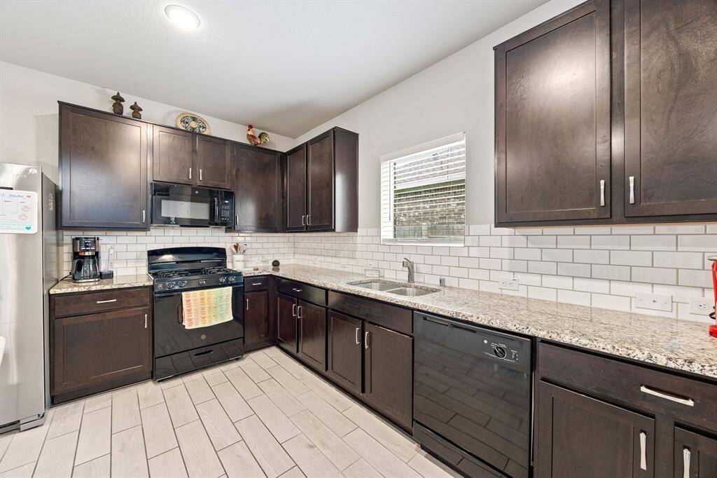 This stunning kitchen displays such a beautiful contrast with the dark stained cabinets, custom neutral paint, granite countertops, light modern backsplash, and SS appliances, recessed lighting, high ceilings and walk in pantry.