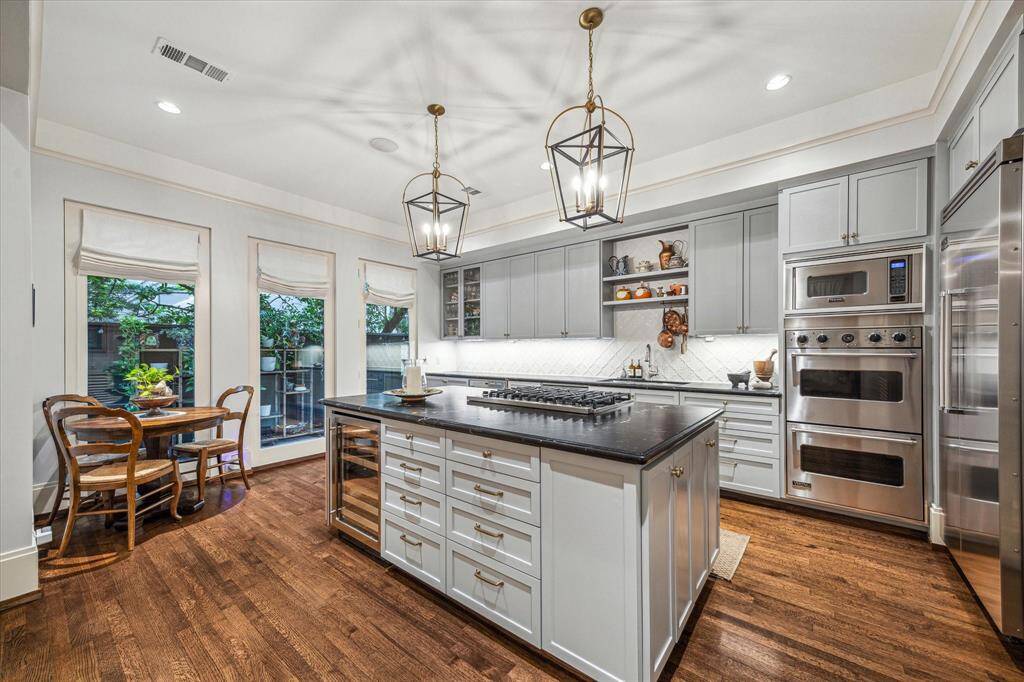 Enjoy morning coffee or casual meals in the sunlit breakfast nook with patio views, adjacent to the well-equipped, high-style kitchen.