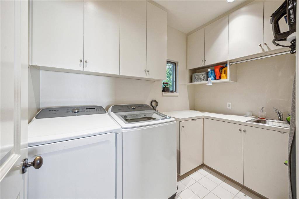 Tucked away off the game room, the laundry room offers excellent built-in cabinetry, a full-size sink, and plenty of counter space for folding and prep.