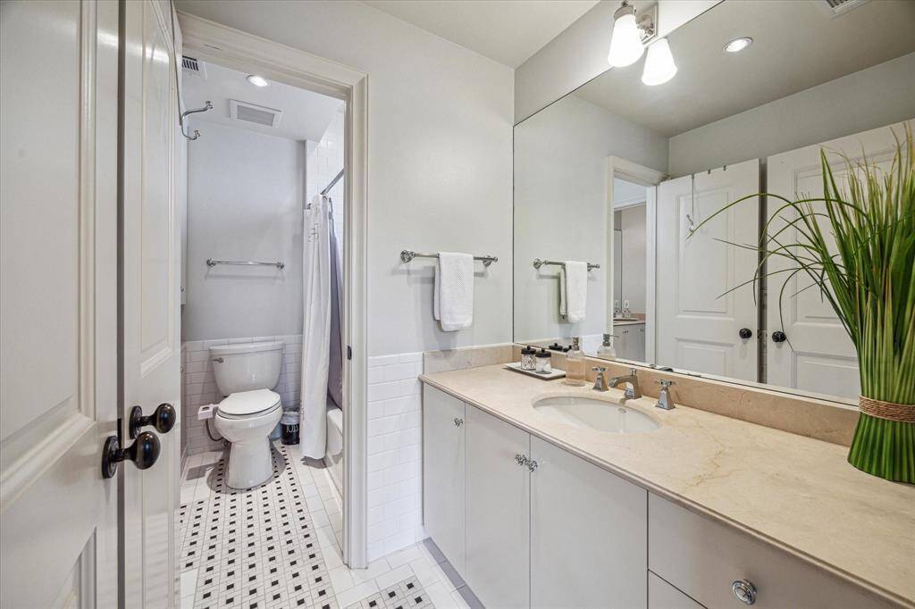 Hollywood bathroom featuring timeless black-and-white mosaic tile, private vanity and abundant storage.