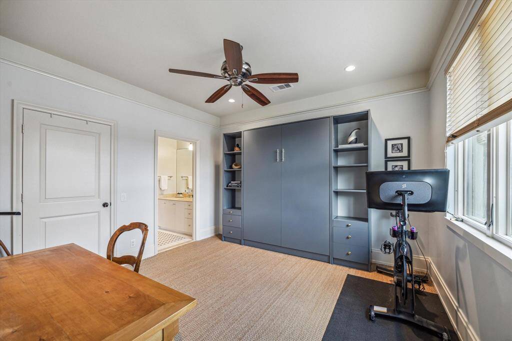 Final secondary bedroom with stylish seagrass flooring, recessed lighting, crown molding, ceiling fan, built-in Murphy bed, and access to a Hollywood bathroom.