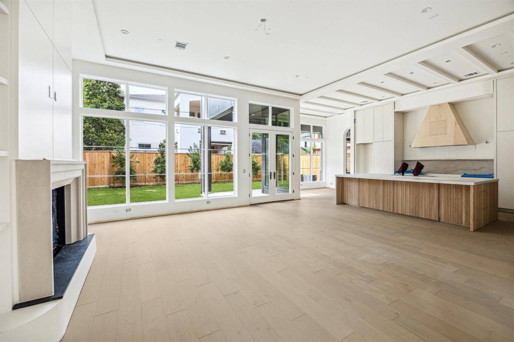 Family Room with 'Shadow Reveal' ceiling and walls of windows with a matching set of doors. There is a ton of natural light in this home.