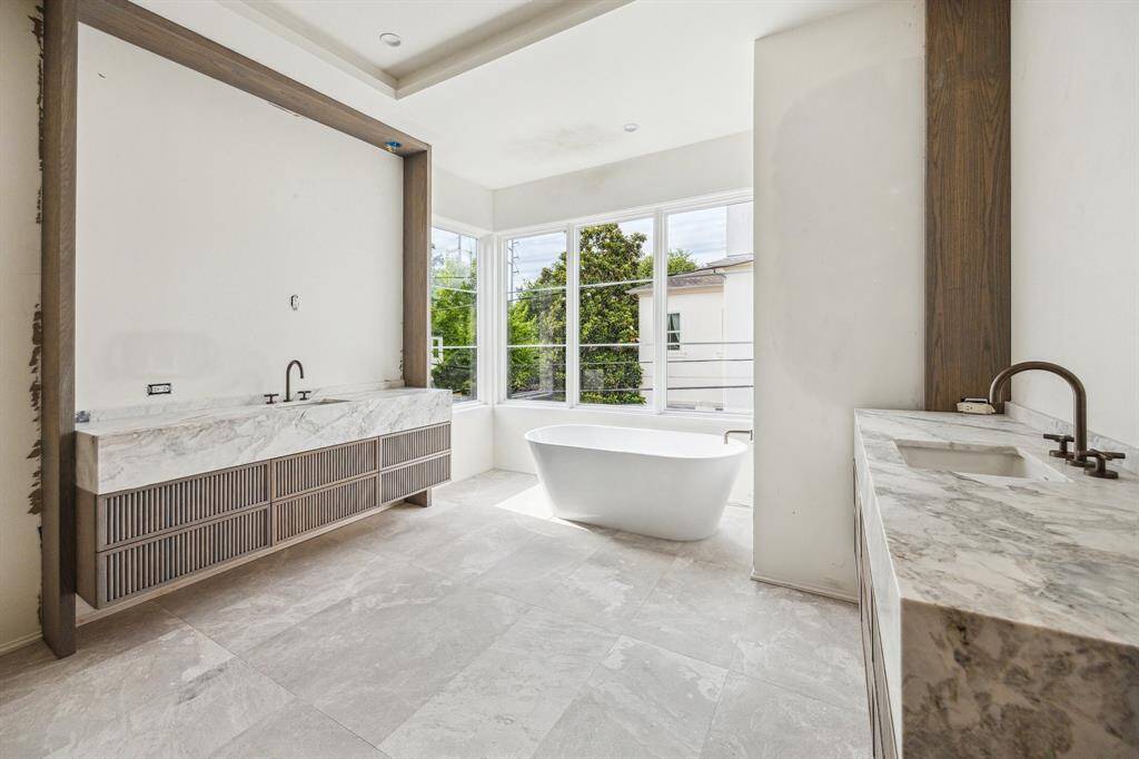 Another view of the Primary Bath which features large dual counters, floating cabinets and beautiful slab counters.
