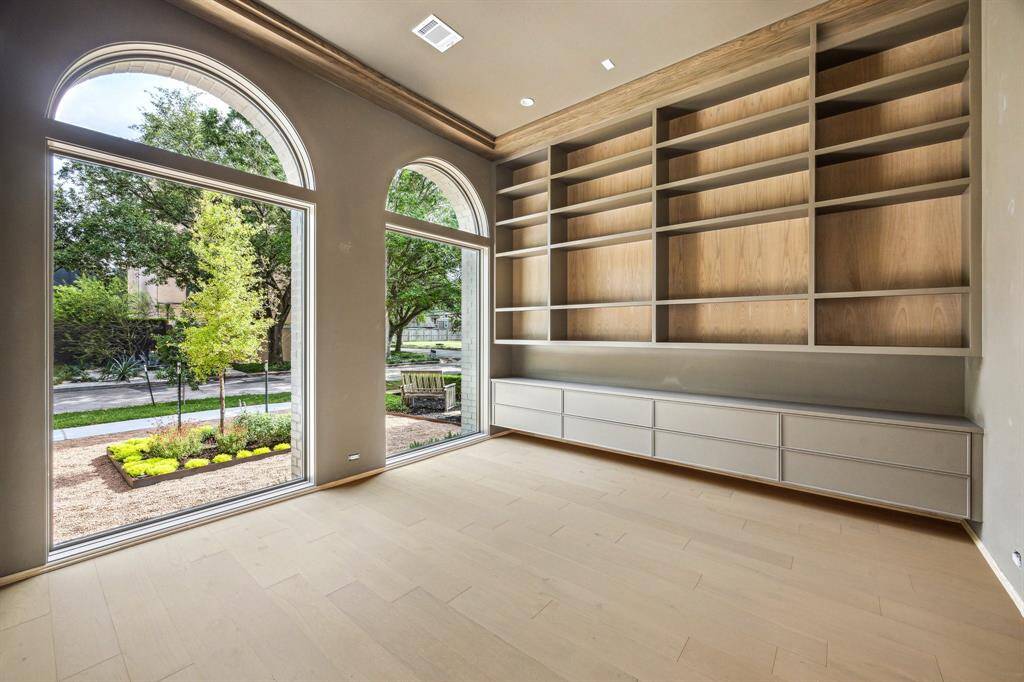 Library off the entrance of the home with built-ins and large windows.