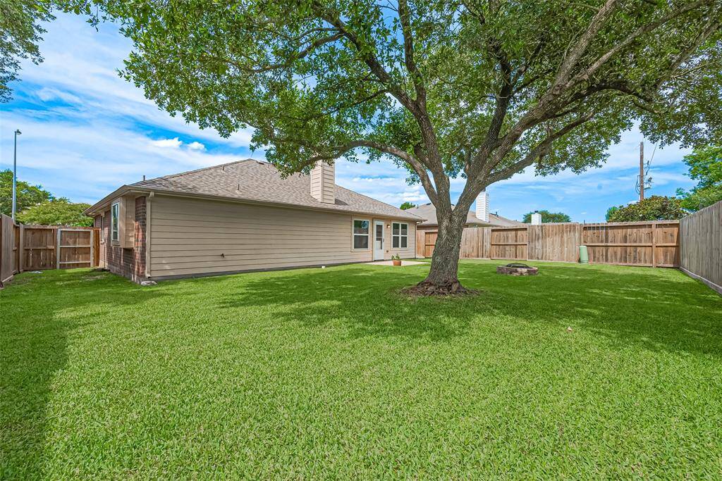 The backyard offers plenty of open green space, perfect for play, gardening, or endless possibilities.
