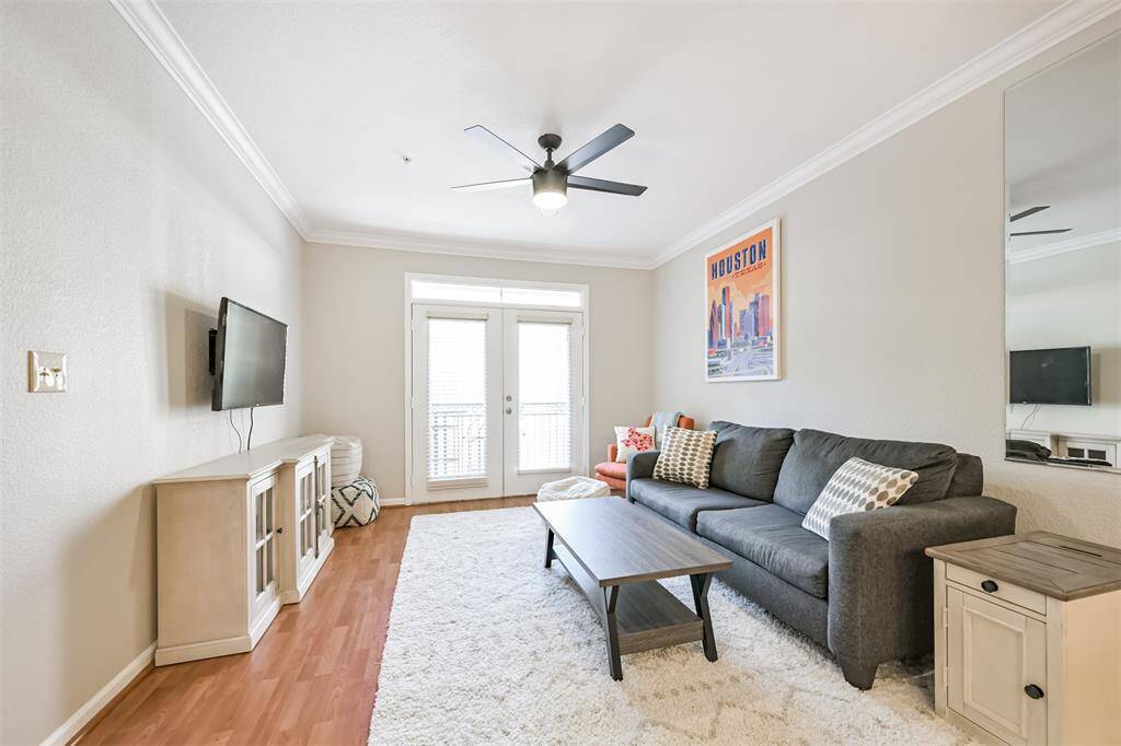Natural light flows through the balcony doors. Crown molding adds an elegant touch.