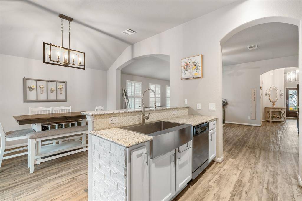 The kitchen features a farmhouse sink and arched doorways adding a touch of elegance.