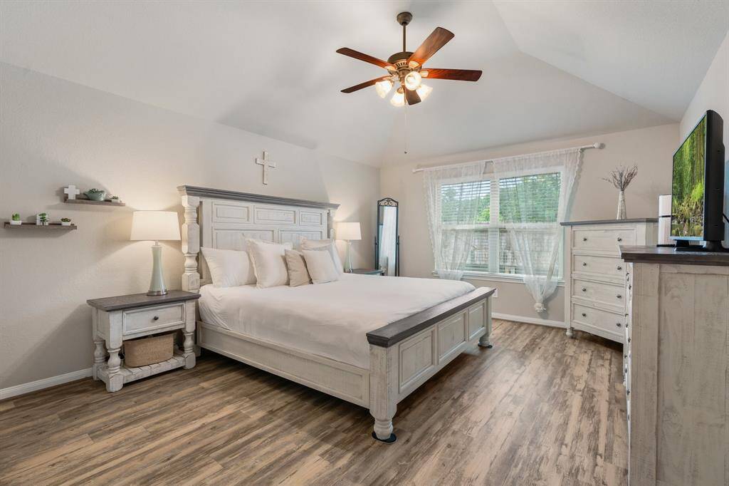 Primary bedroom is spacious yet cozy with natural light and a view of the private back yard