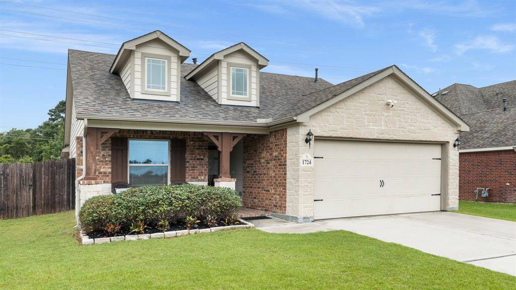 two-car garage and dormer windows. Features a well-maintained front lawn, inviting covered porch, and a fenced backyard for privacy. Ideal for comfortable living.