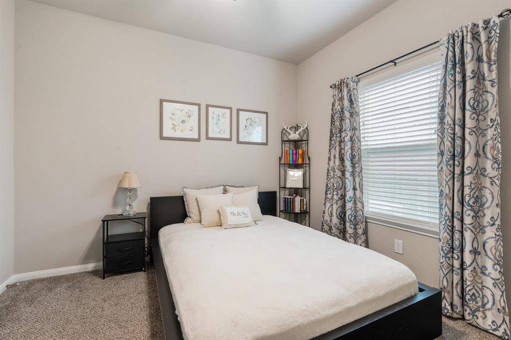 Cozy secondary bedroom with neutral walls and carpet.