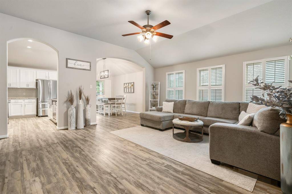This inviting living space features an open floor plan and ample natural light from multiple windows with elegant plantation shutters.
