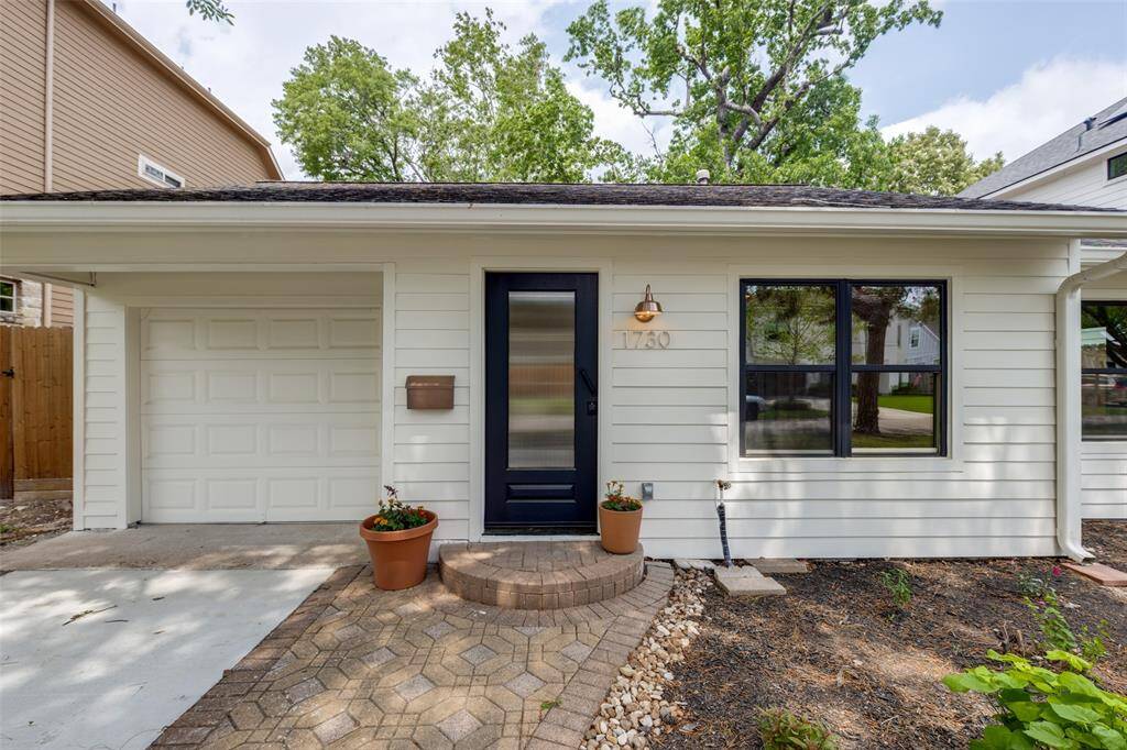 Elegant paver path leads from the new driveway to an inviting front porch creating a welcoming entry.  The modern black front door adds a stylish touch.