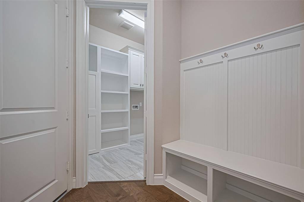 Custom cabinets in the laundry room along with hall tree and a large walk in pantry