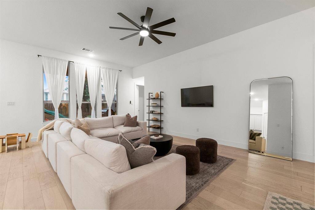 Additional highlights of the Family Room include rich engineered wood plank flooring, elegant 6-inch baseboards, and a stylish upgraded ceiling fan with integrated lighting for enhanced comfort and design.