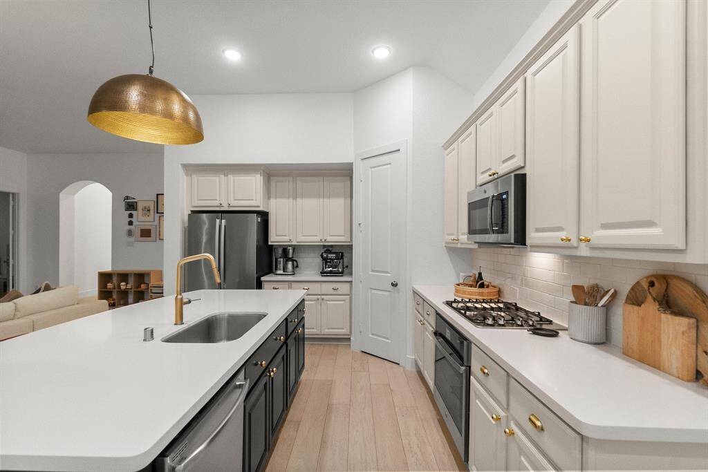 A pristine view of what this extraordinary kitchen has to offer.  Stainless steel appliances include a 4 burner gas cooktop, convection oven, dishwasher, refrigerator, and microwave.  This elegant kitchen boasts plenty of rich wood cabinets and sleek quartz counter top workspace.